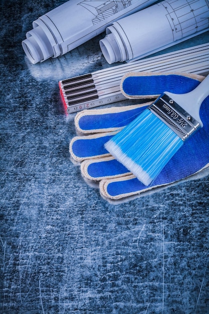 Houten meter penseel veiligheidshandschoenen en opgerolde blauwdrukken verticale weergave