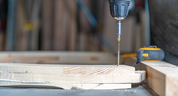 Houten meubels schroeven in een schrijnwerk met een elektrische boor