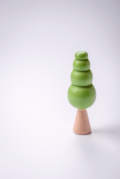 Houten model van een boom met een groene kroon en stam op een witte achtergrond