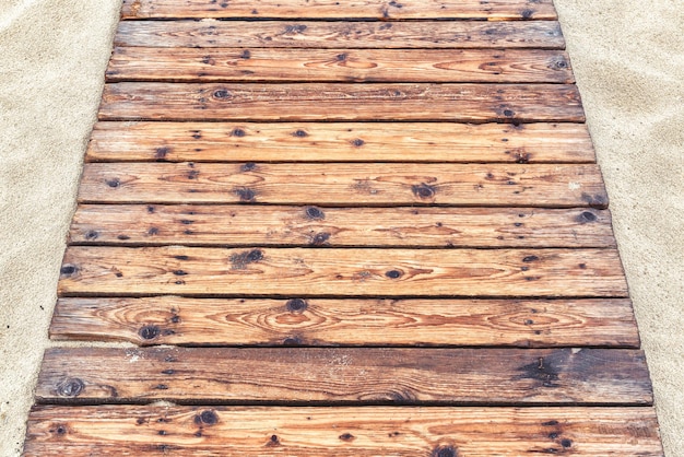 Houten pad op een zandstrand in de zomer