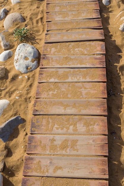 Houten pad op het zand naar de zee