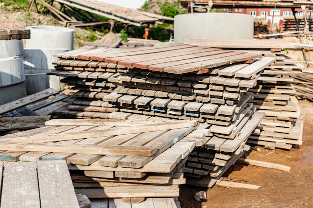 Houten pallets op een bouwplaats. Hergebruik van bouwmaterialen. Bestrating gereedschap.