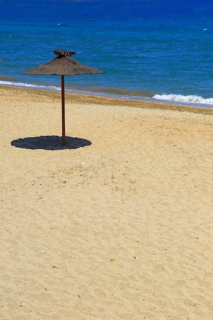 Houten parasol op zandstrand