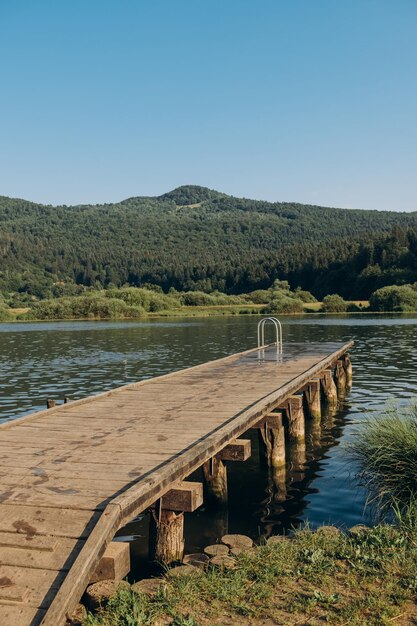 Houten pier meer omringd door bergen Slovenië Het concept van zomervakantie vakantie