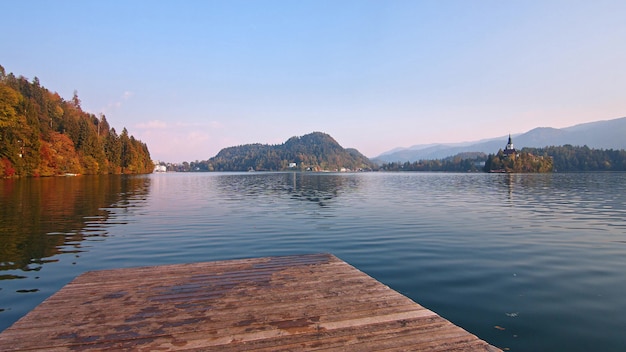 Foto houten pier op het bled meer in slovenië met beroemde eiland en