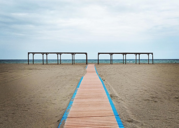 Foto houten pier op het strand tegen de lucht