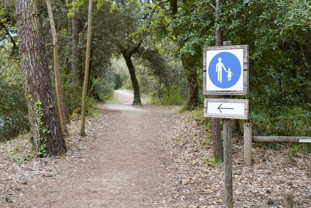 Houten pijl die de richting van het voetpad wijst voor een wandelpad in een natuurlijke boswandeling