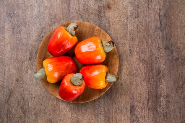 houten plaat met een paar cashewnoten over een houten ondergrond. Vers fruit.