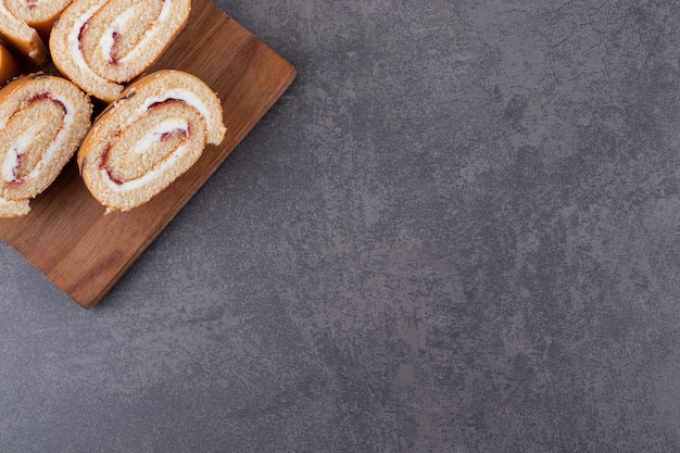 Houten plaat van gesneden biscuitgebak op stenen tafel.