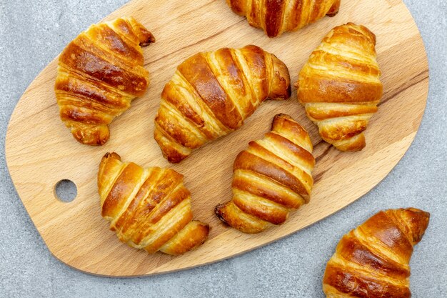 Foto houten plank met vers gebakken croissants