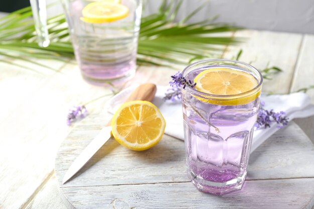 Houten plank met verse lavendellimonade in glas op tafel