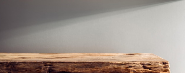 Houten plank op een achtergrond van beige muur in het zonlicht