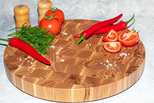 Houten plank voor het snijden van handgemaakte producten met gehakte groenten op een lichte achtergrond