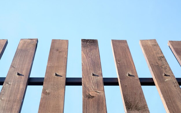 Houten plankomheining op blauwe hemelachtergrond