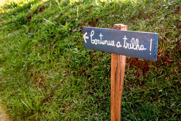 Houten plaquette in het gras Vertaling Ga door met het pad