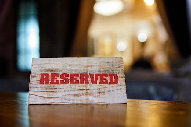 Houten plaquette met het opschrift Gereserveerd op de restauranttafel