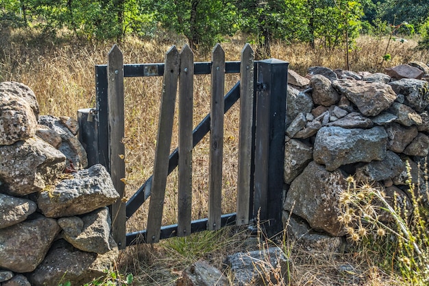 Houten poort in een droge stenen muur