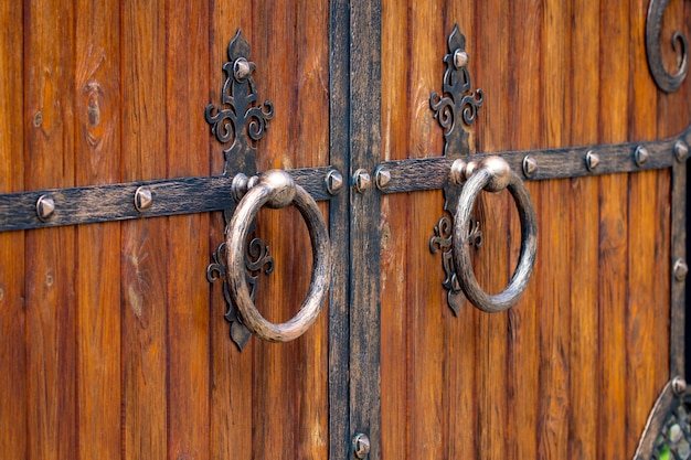 Houten poort met smeedijzeren elementen close-up.