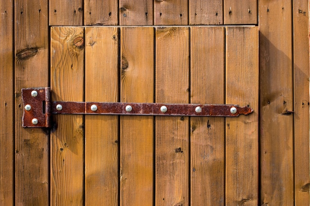 Houten poort met smeedijzeren elementen close-up.