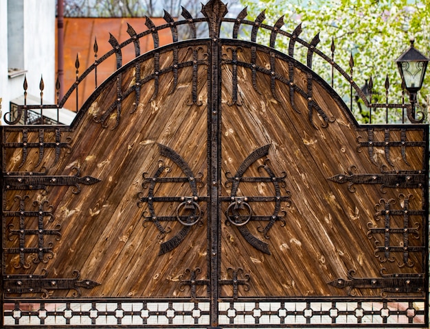 Houten poort met smeedijzeren elementen close-up.