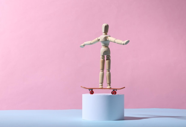 Houten pop met een skateboard op de standaard Blauwroze achtergrond Minimalisme