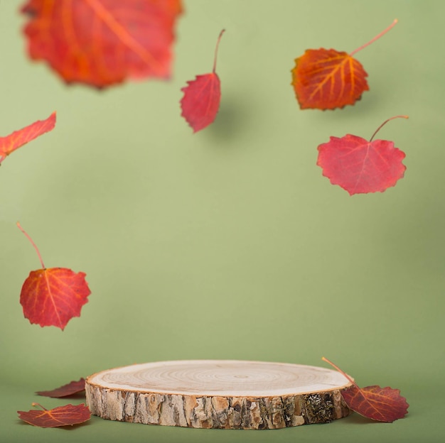 Houten product display met vliegende rode herfstbladeren op groene achtergrond herfst mockup