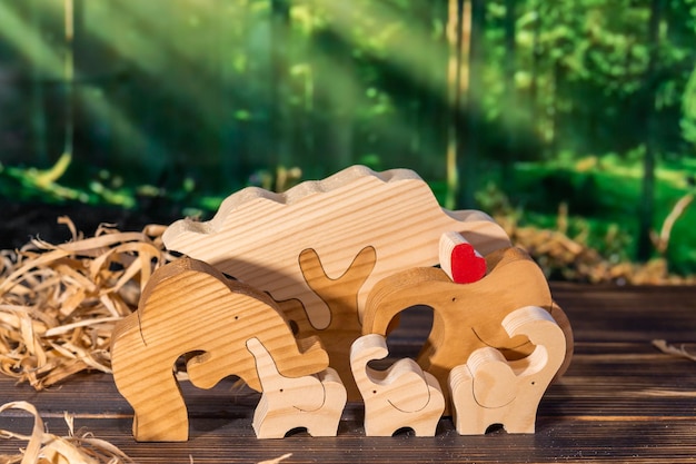 Houten puzzel in de vorm van een familie handgemaakte olifanten op de achtergrond van het bos
