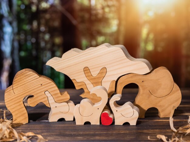 Houten puzzel in de vorm van een familie handgemaakte olifanten op de achtergrond van het bos