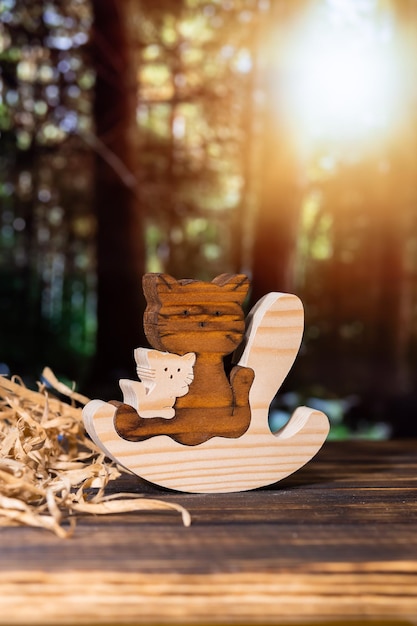 Houten puzzel in de vorm van een handgemaakte kattenfamilie op de achtergrond van het bos