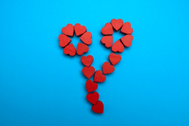 Houten rode harten zijn aangelegd in de vorm van een bloem op een blauwe achtergrond Bovenaanzicht plat gelegd