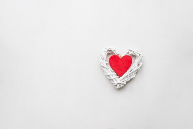 Houten rood hart op een witte muur. liefde en romantiek. Hart vorm. De relatie tussen geliefden. Minimalisme.