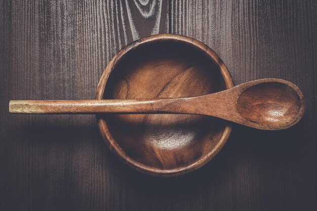 Houten saladebord en lepel op bruine tafel