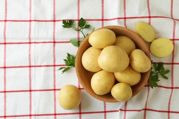 Houten schaal met jonge aardappel op tafelkleed