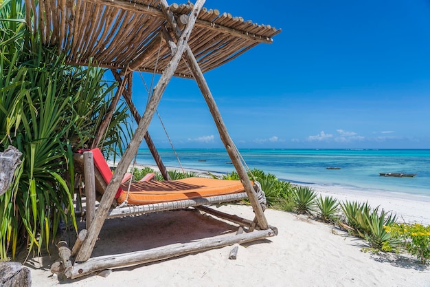 Houten schommel onder een baldakijn op het tropische strand bij het zee-eiland zanzibar tanzania oost-afrika