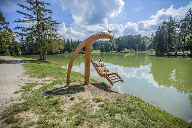 Houten schommel over Lake Bloke in Nova Vas, Slovenië op een zonnige dag