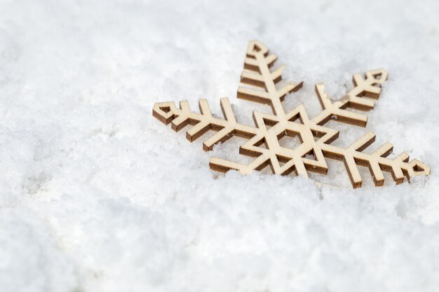 Houten sneeuwvlok op sneeuw