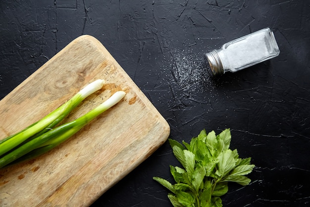 Houten snijplank kruid ingrediënten op stenen tafel en zout