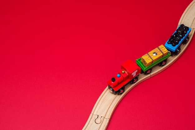 Houten speelgoedtrein op spoorweg op rode achtergrond educatief speelgoed
