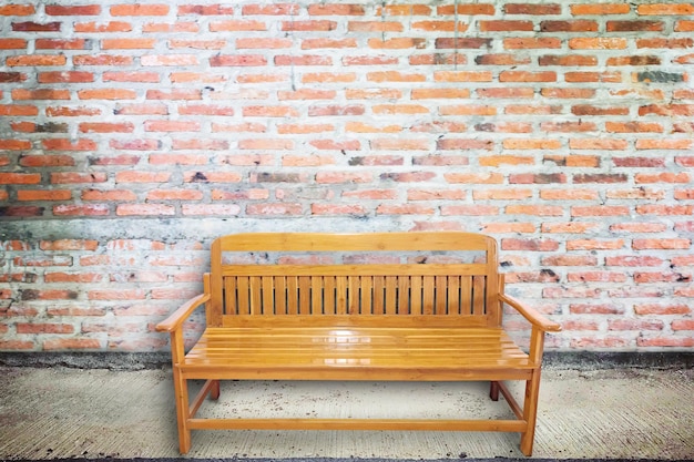 Houten stoel op een oude straat met een betonnen muur.