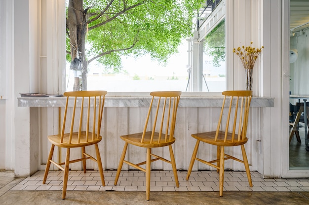 Houten stoelen met marmeren bar en boom aan de buitenkant