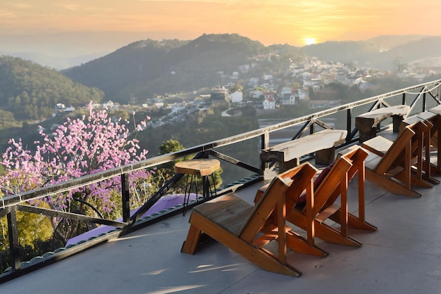 Houten stoelen zonder mensen tegen zonsondergang en sakuraboom in de bergen van Da Lat in Vietnam