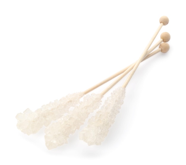 Houten stokjes met suikerkristallen op wit wordt geïsoleerd Smakelijke rock snoepjes