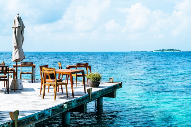 houten tafel en stoel met uitzicht op zee op de Malediven