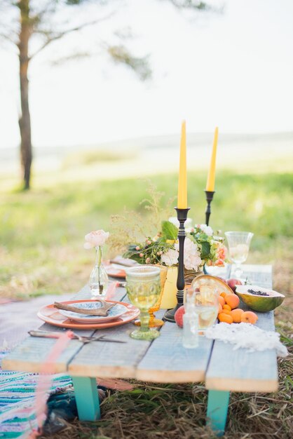 Houten tafel gemaakt van planken in de natuur met fruit en bloemen