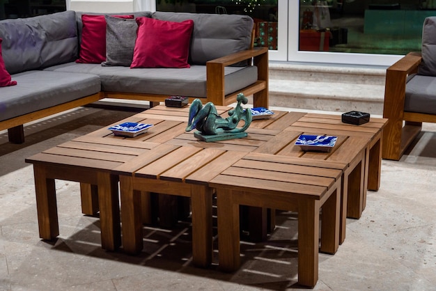 Houten tafel met borden en beeldhouwwerken op de patio