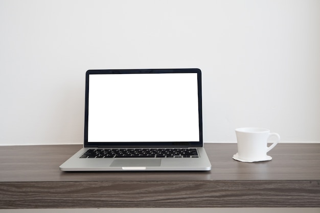 Houten tafel met leeg scherm laptop en warme koffie