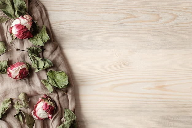 Houten tafel met verdorde bloemen op beige doek