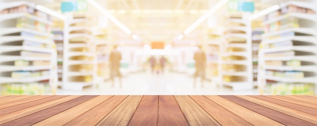 Houten tafelblad met supermarkt supermarkt gangpad interieur wazig achtergrond met bokeh licht