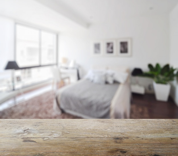 Houten tafelblad met vervaging van moderne slaapkamer interieur als achtergrond