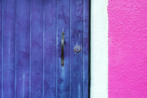 Houten violette deur en roze muur. Close-up bekijken. Kleurrijke architectuur in Burano-eiland, Venetië, Italië.